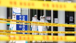 Medical staff wearing protective suits  outside a hospital in Daegu, South Korea, Sunday, March 1, 2020. The coronavirus has claimed its first victim in the United States as the number of cases shot up in Iran, Italy and South Korea and the spreading outbreak shook the global economy.