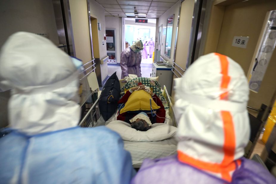 Medical staff transport a coronavirus patient within the Red Cross hospital in Wuhan on February 28. 