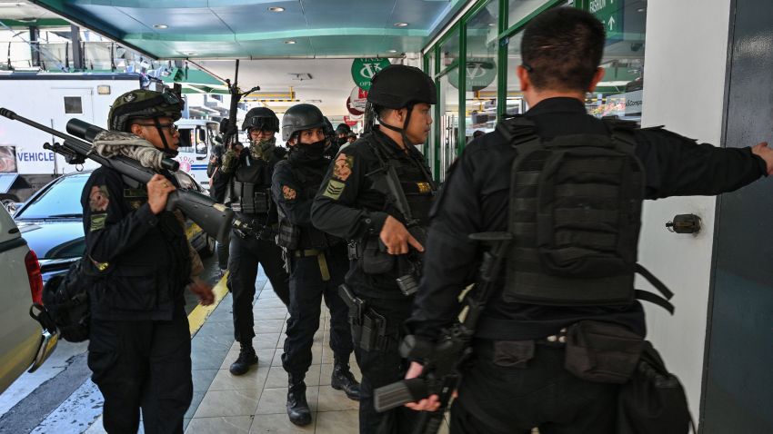 Members of a police SWAT team take positions outside one of the entrances to a mall after a hostage situation was reported in suburban Manila on March 2, 2020. - Heavily armed police were deployed at the mall in the Philippine capital Manila after reports that a disgruntled employee was holding a group of people hostage, an AFP journalist saw. (Photo by Ted ALJIBE / AFP) (Photo by TED ALJIBE/AFP via Getty Images)