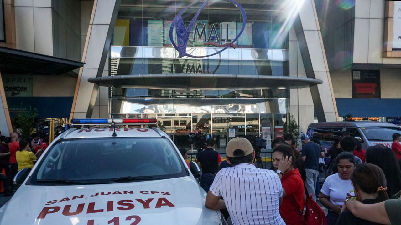 Frightened onlookers gather outside as heavily armed police arrived at the building.
