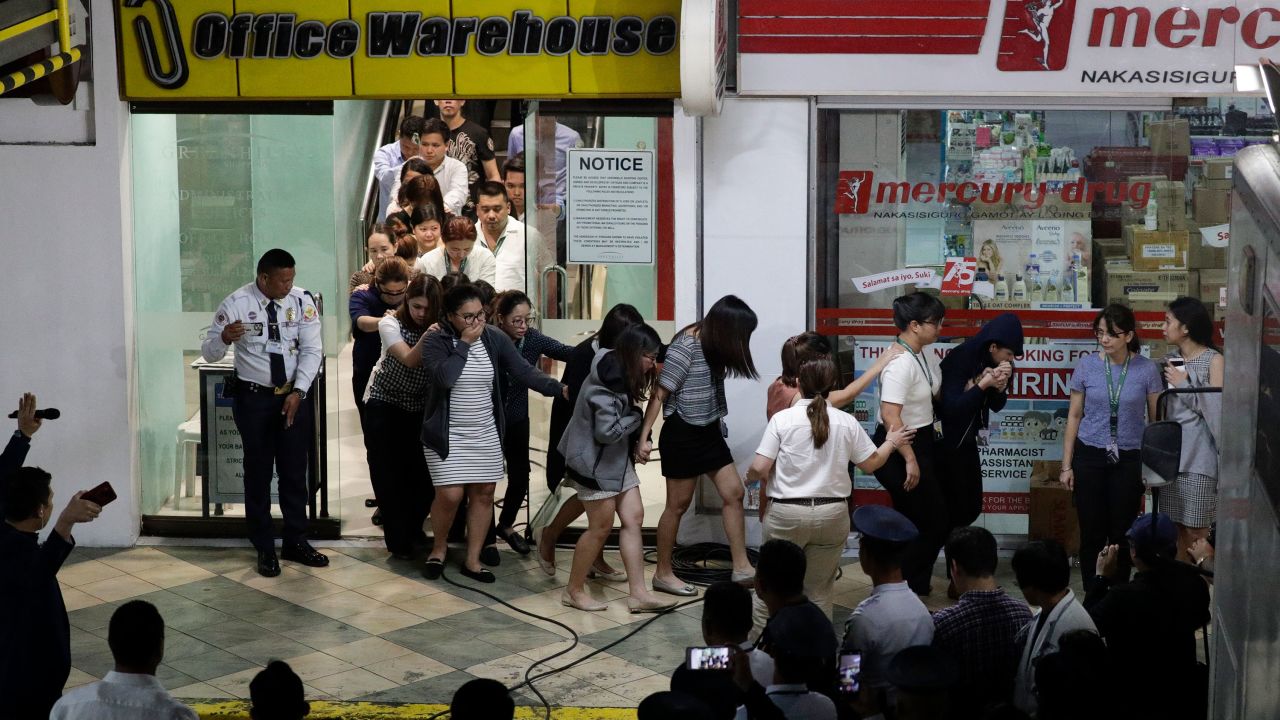 Hostages walk out of the Virra Mall near Manila, Philippines after they were held by a sacked security guard in a day-long stand-off.