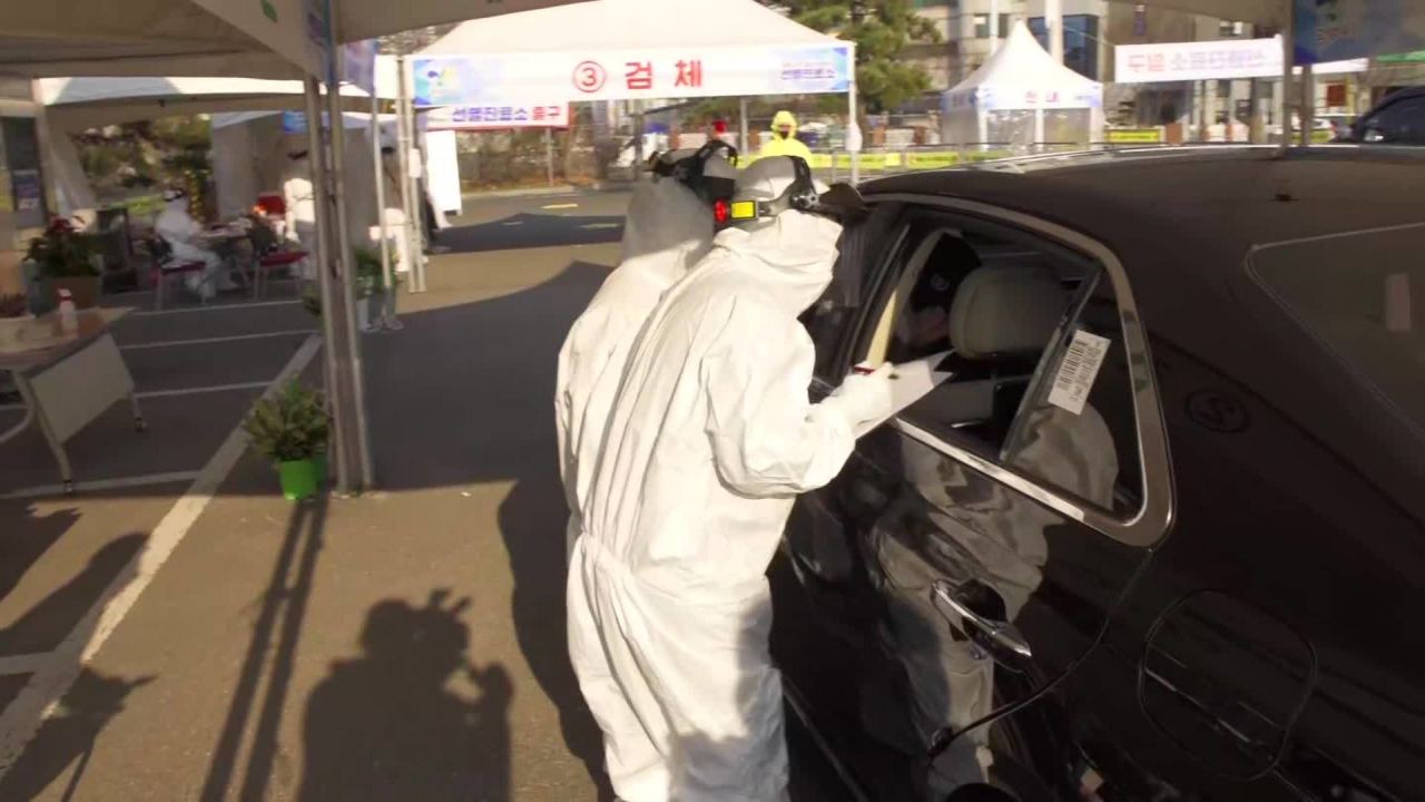 Health officials test patients through a car window at the drive-through site.