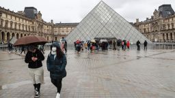 Two people walk away from the Pyramid, the main entrance to the Louvre museum which was once a royal residence, located in central in Paris on March 2, 2020. - The Louvre in Paris, the world's most visited museum, was closed for a second day running on March 2, 2020, after staff refused for a second day running to work due to coronavirus fears, a union said. The Paris museum insisted that closure was not necessary in response to fears over the virus, which has spread to over 60 countries after first emerging in China late last year. (Photo by Ludovic Marin / AFP) (Photo by LUDOVIC MARIN/AFP via Getty Images)
