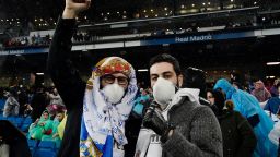 Two Real Madrid fans pose wearing protective masks in the light of the novel Coronavirus, COVID-19, outbreak before the Spanish League football match between Real Madrid and Barcelona at the Santiago Bernabeu stadium in Madrid on March 1, 2020. (Photo by JAVIER SORIANO / AFP) (Photo by JAVIER SORIANO/AFP via Getty Images)