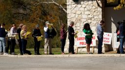 In this Friday, Feb. 28, 2020 photo, voters wait in line at an early polling site in San Antonio.  California and Texas are the most populous states in the nation and the biggest delegate prizes for the candidates, yet they also present a stark contrast in voting laws.