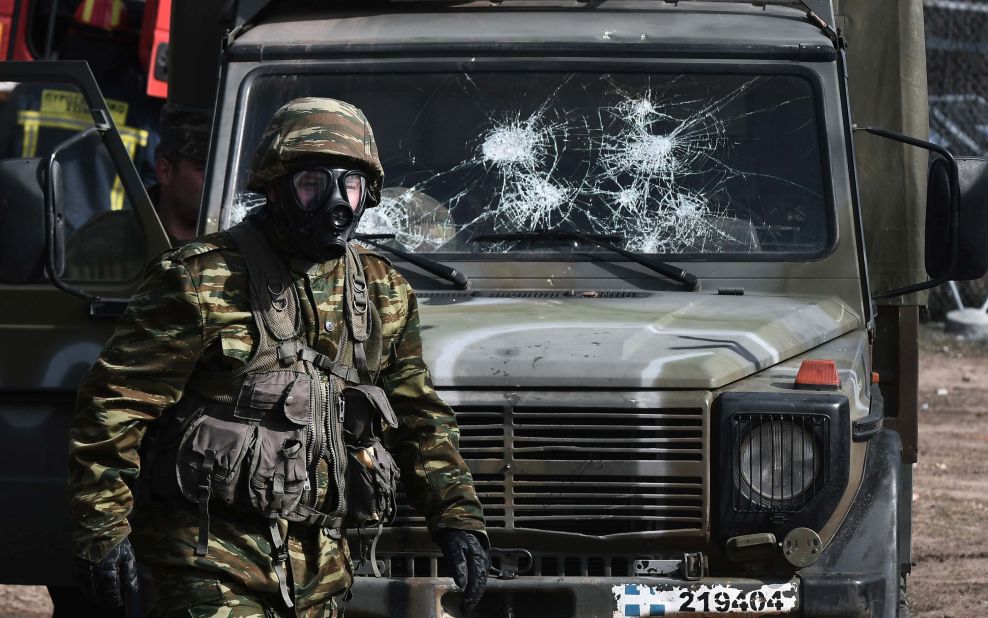 A soldier passes a Greek army vehicle with a damaged windshield at the Greek border near Kastanies on March 2.