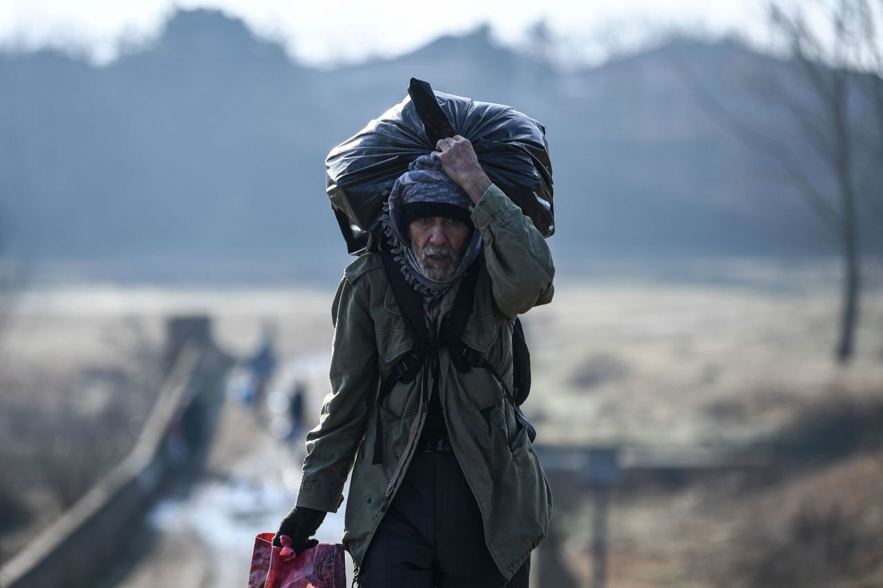 A migrant carries his belongings as he walks toward the Maritsa river to attempt to cross to the Greek side.