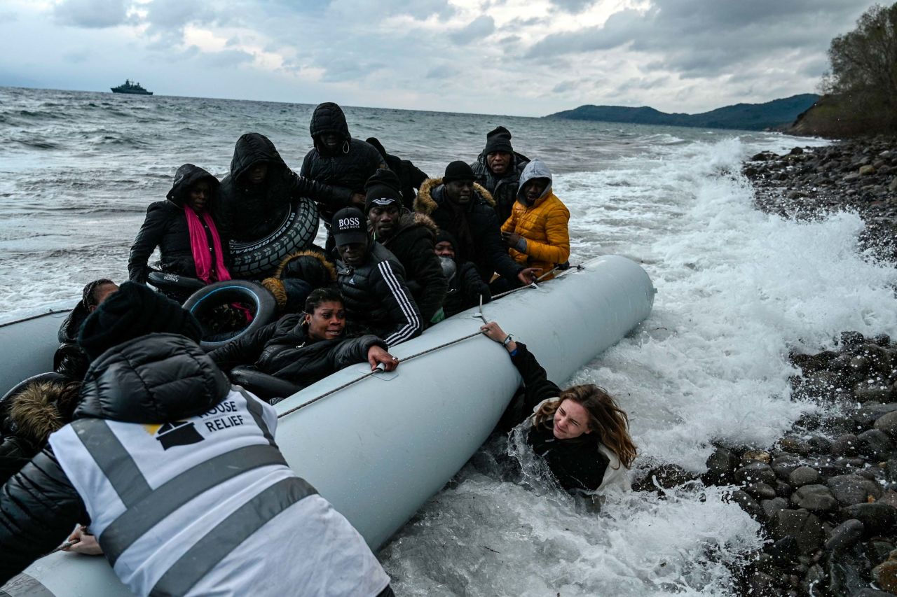 A dinghy transporting migrants lands in Lesbos after they were escorted by a war ship during their crossing between Turkey and Greece on February 29.
