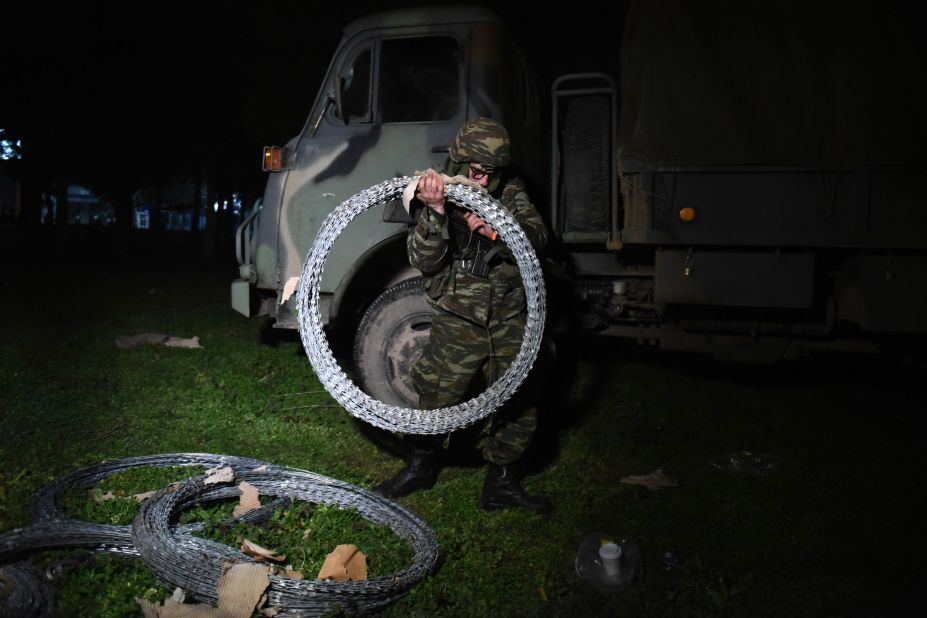 A Greek soldier carries razor-wire fencing at the Kastanies border gate on February 29.