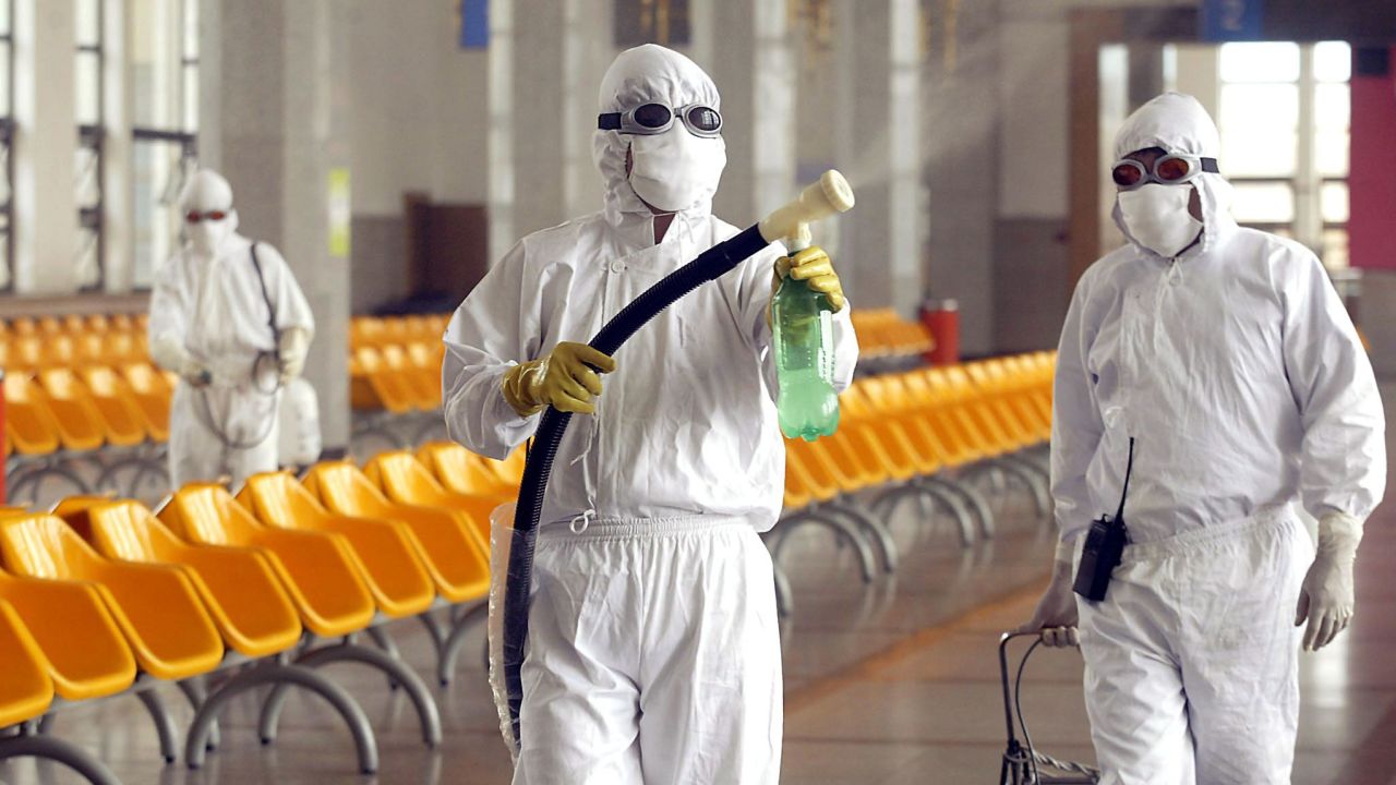 Workers disinfect the waiting room of Beijing railway station in the fight against SARS, May 2003.  