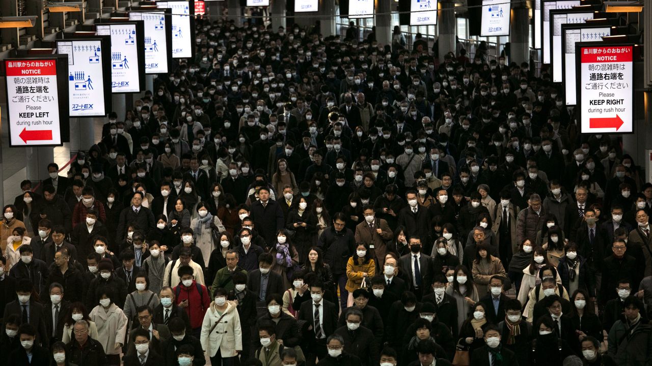 A large crowd wearing masks commutes through Shinagawa Station in Tokyo, Tuesday, March 3, 2020.