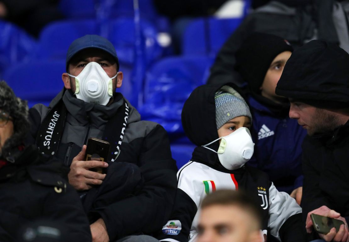 Juventus fans wear protective masks during their side's Champions League clash against Lyon.