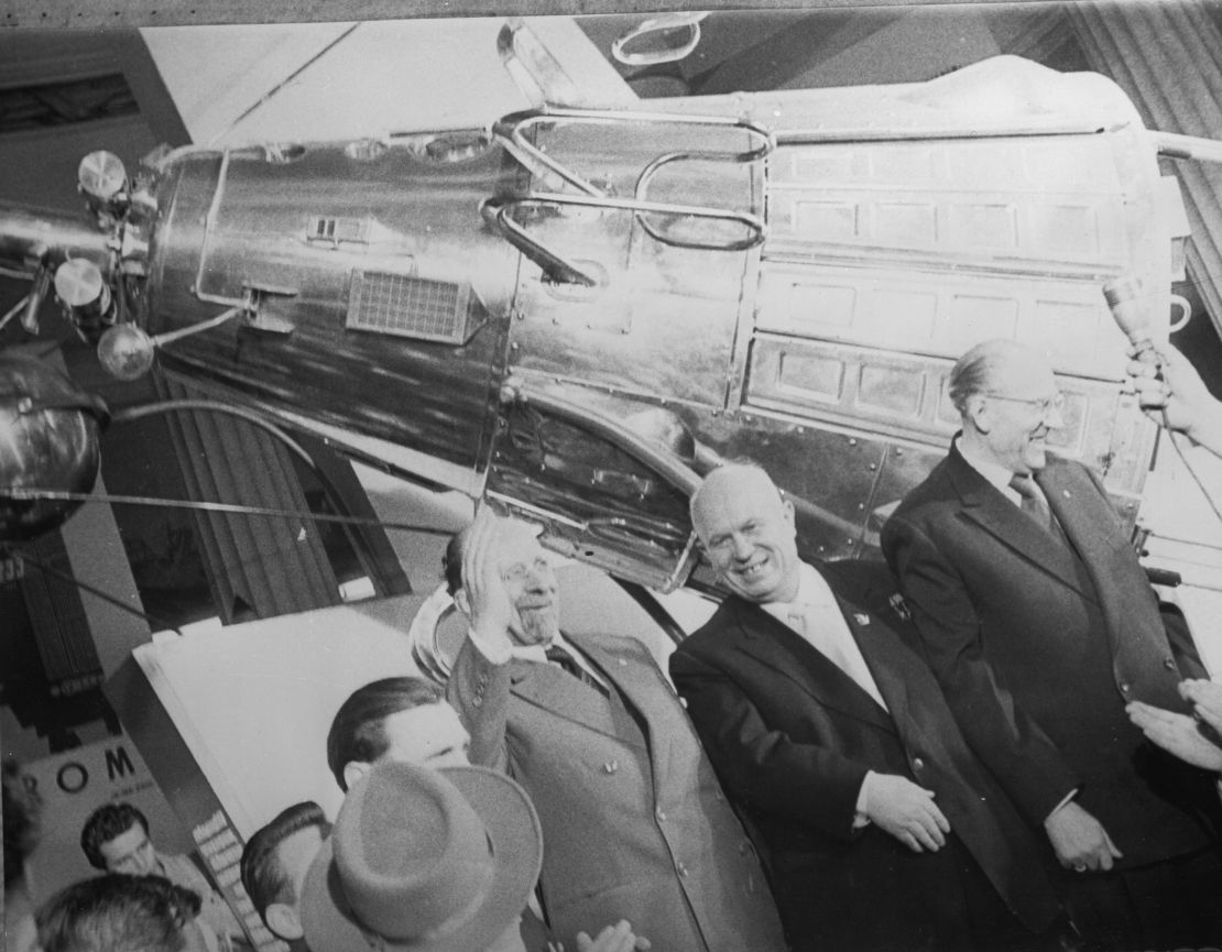 Nikita Khrushchev, center, who led the Soviet Union during the first part of the Cold War, stands in front of a model of Sputnik III.