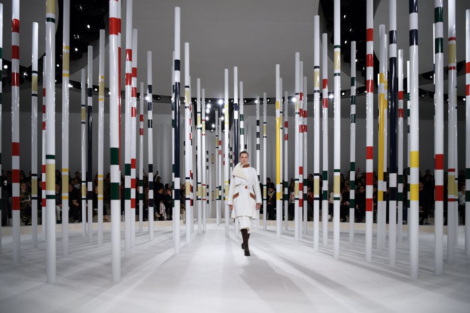 A model walks through a modernist woodscape at Hermes Autumn-Winter 2020-21 