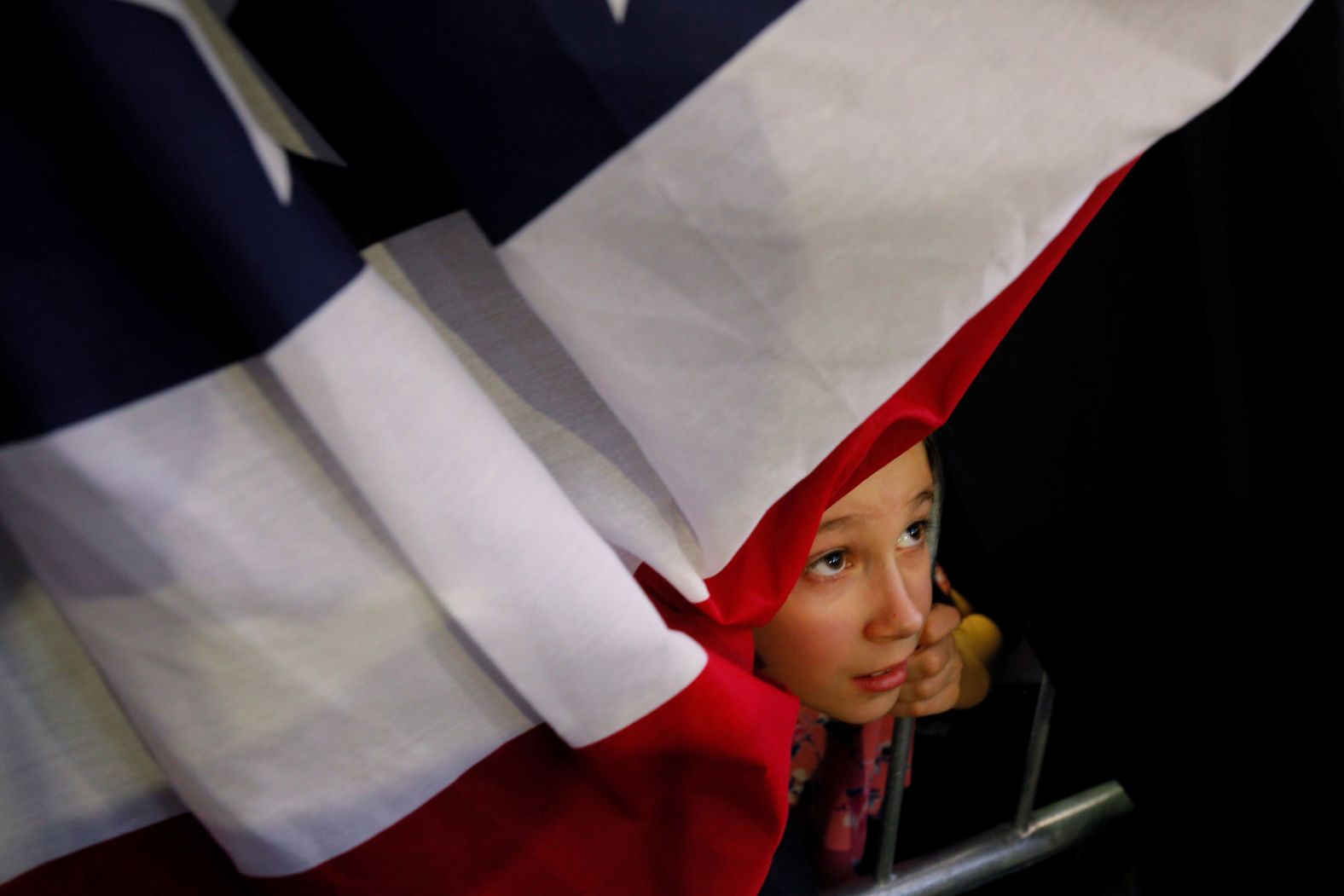 A girl looks through the bunting as US Sen. Elizabeth Warren speaks at her Super Tuesday rally in Detroit.
