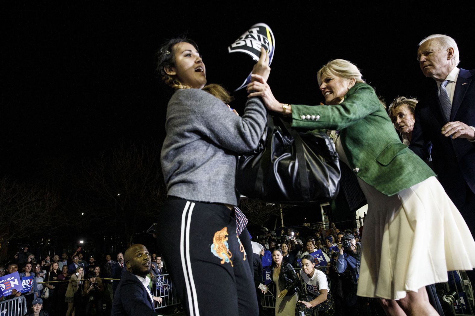 Biden's wife, Jill, blocks a protester who charged the stage during his speech in Los Angeles. The protester was holding a sign that said "Let dairy die."