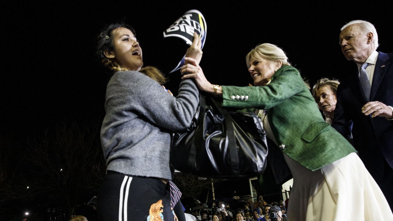 Former Vice President Joe Biden, a Democratic presidential candidate, watches as his wife, Jill Biden, center, blocks a protester from arriving onstage during a primary night rally in the Baldwin Hills neighborhood of Los Angeles, on Tuesday, March 3. 