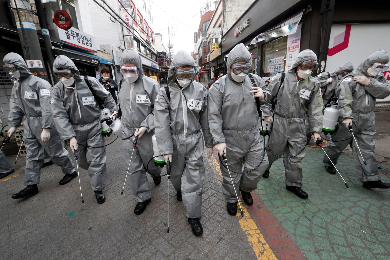 Soldiers spray disinfectant throughout a shopping street in Seoul.