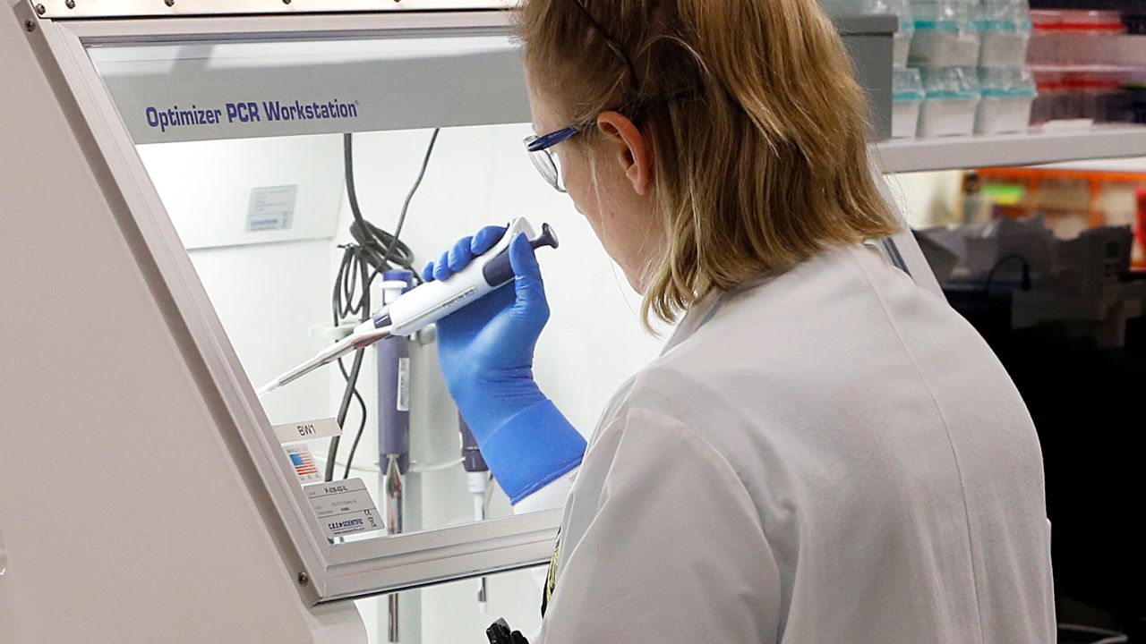 An employee of the Department of General Services Division of Consolidated Laboratories' Virginia Public Health Labratory adds chemicals in the second step of testing a sample for the Coronavirus at the lab in Richmond, Va. on Wednesday, March 4, 2020. The three step process of rendering a suspected virus sample inert, adding chemicals to help in the identity process and finally determine a positive or negative result can take from 24-48 hours. As of Wednesday all results have been negative for 17 people in the state tested.( Joe Mahoney/Richmond Times-Dispatch via AP)