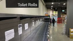 A shopper passes empty shelves usually stocked with toilet paper in a supermarket in Melbourne on March 5, 2020. - COVID-19 coronavirus fears have triggered runs on several products, including hand sanitisers and face masks, with images of shoppers stacking trolleys with toilet rolls spreading on social media. (Photo by William WEST / AFP) (Photo by WILLIAM WEST/AFP via Getty Images)