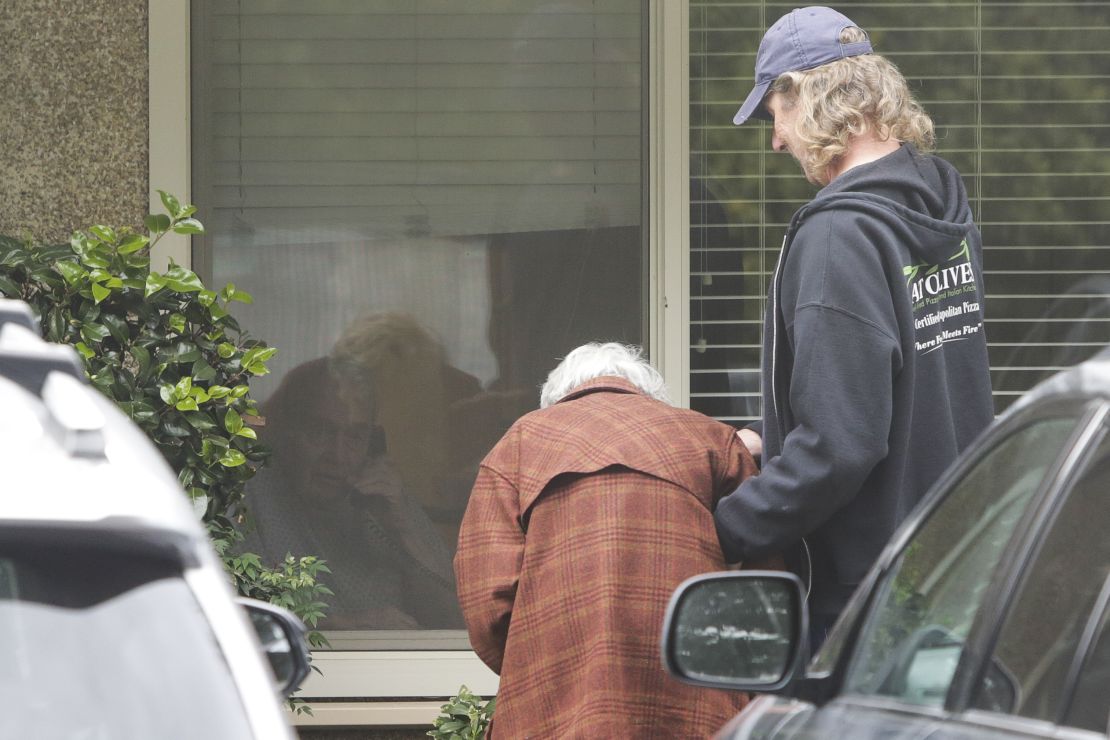 Charlie Campbell  takes his mom Dorothy Campbell, 88, to see her husband Gene Campbell, 89, through his room window at the Life Care Center nursing home in Kirkland, Washington. 