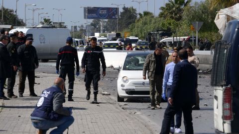 Police and forensic experts gather evidence at the scene of Friday's attack in Tunis.