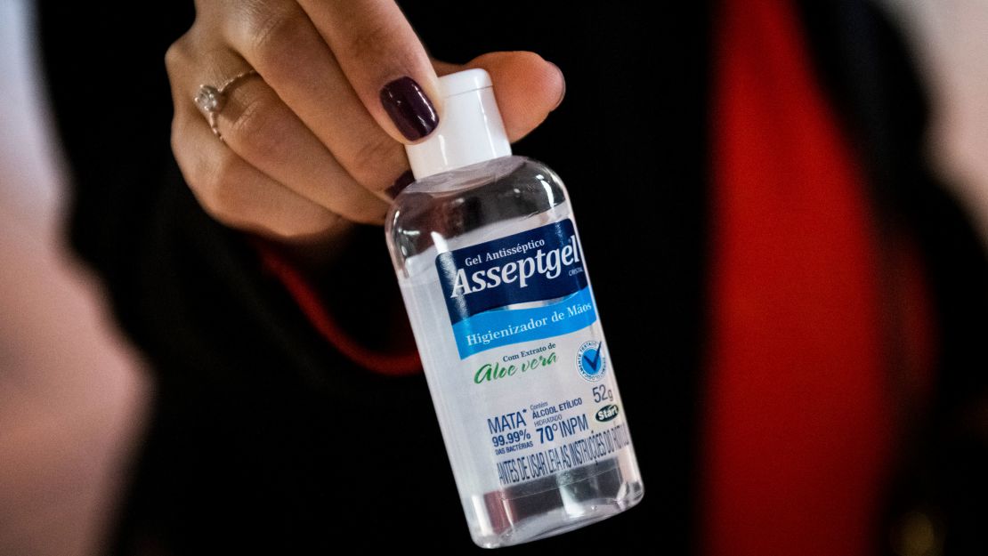 Vanessa Gayer holds a bottle of antibacterial gel she brought with her from Brazil to New York.