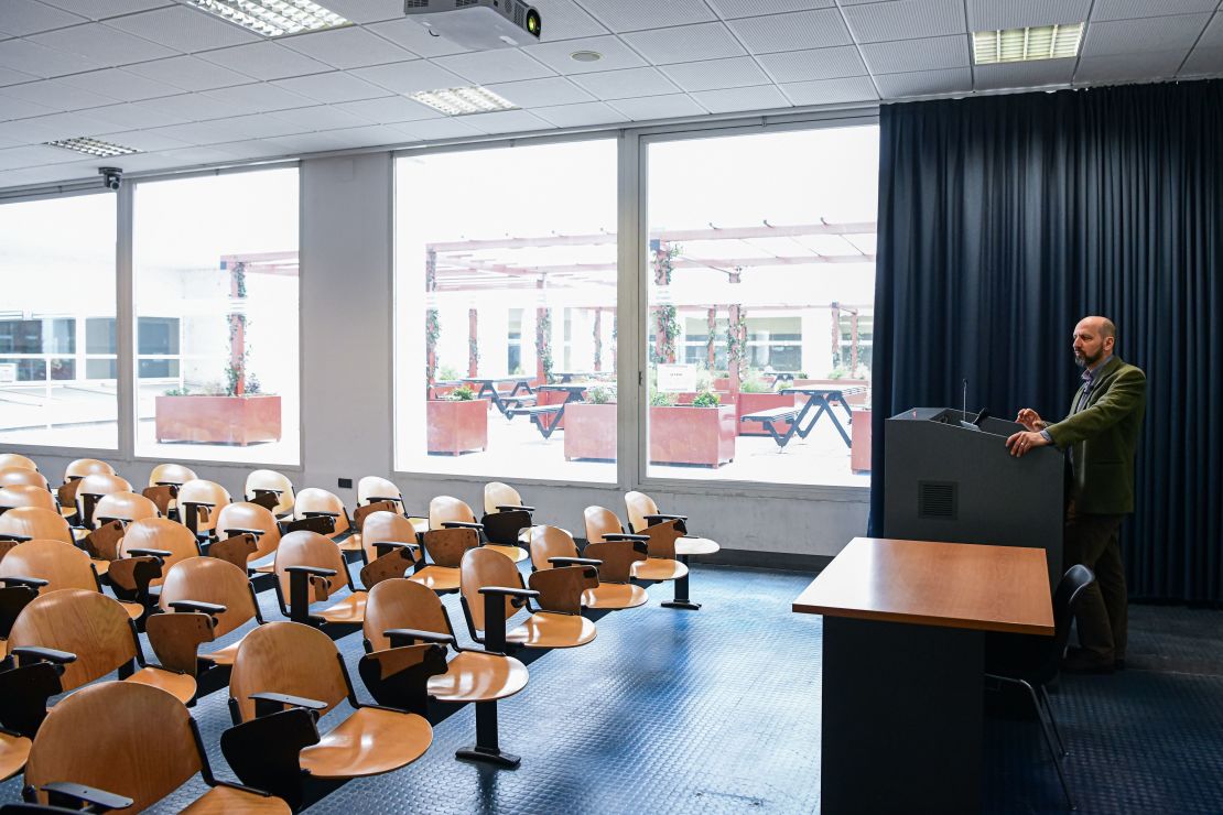 Professor Maurizio Casiraghi records a lesson on the evolution of genomes in an empty classroom in Milan.