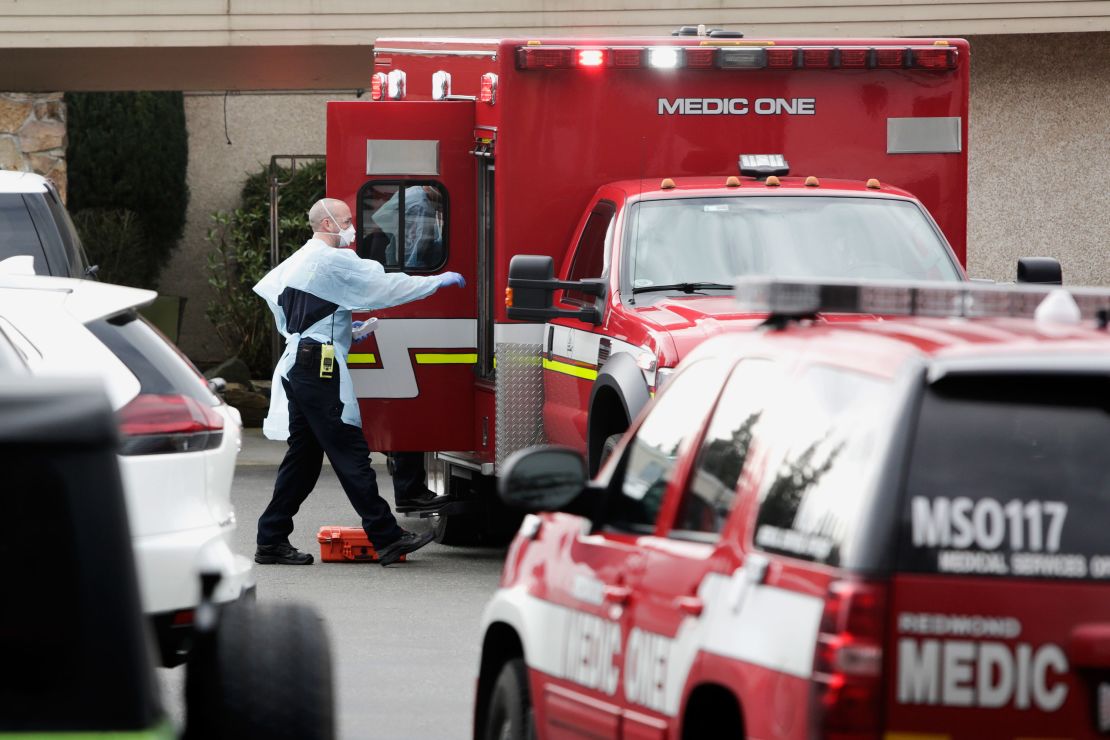 Ambulance staff prepare to transport a patient from the Life Care Center nursing home where some patients have died from coronavirus in Kirkland, Washington.