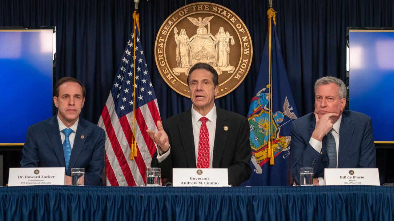 New York state Gov. Andrew Cuomo (center) says the state will make hand sanitizer.