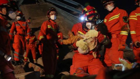 Rescuers carried a young boy from the rubble.