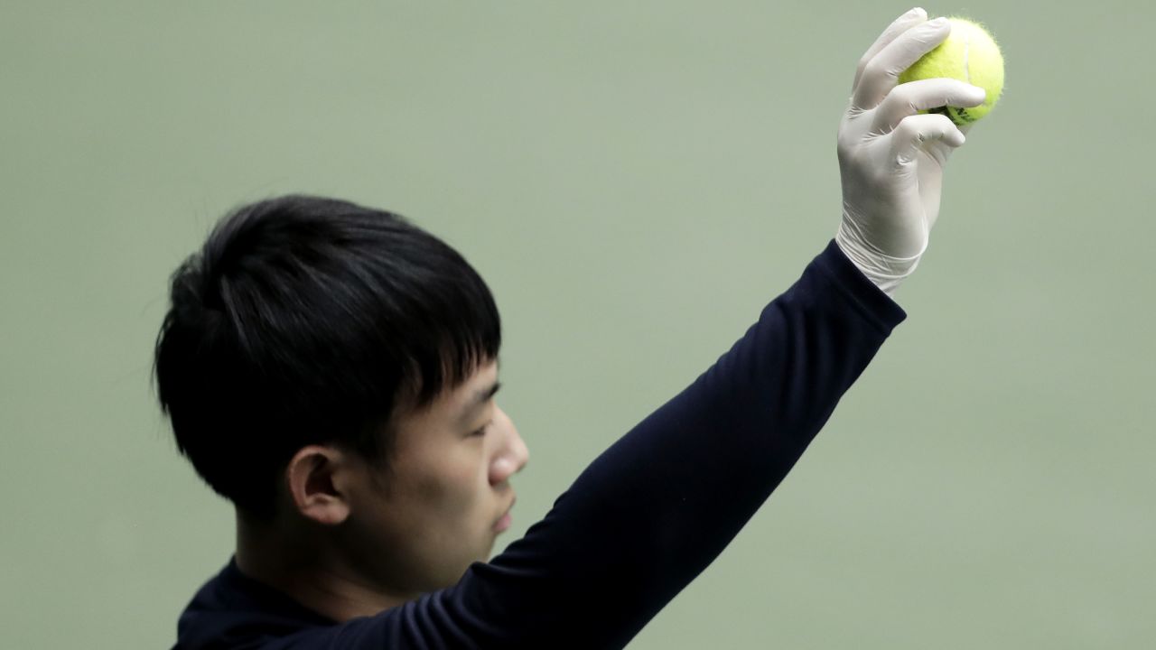 A ball boy wears a rubber glove as a preventive measure against the novel coronavirus.