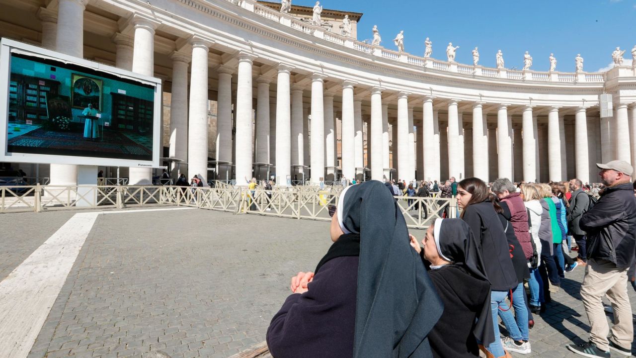 Nuns and faithful watch Pope Francis deliver the Angelus prayer on a giant screen, in St. Peter's Square, at the Vatican, Sunday, March 8, 2020. Italy's Prime Minister Giuseppe Conte announced a sweeping coronavirus quarantine early Sunday, restricting the movements of about a quarter of the country's population in a bid to limit contagions at the epicenter of Europe's outbreak. (AP Photo/Andrew Medichini)