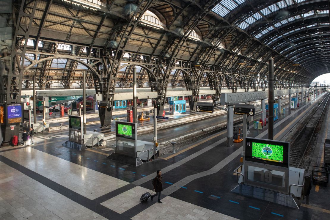 A woman walks in the almost deserted Central Station in Milan on Sunday after the lockdown was imposed overnight.  