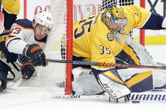 Edmonton Oilers' Tyler Ennis reaches for the puck as Nashville Predators goaltender Pekka Rinne blocks a shot in the first period of an NHL hockey game March 2 in Nashville.