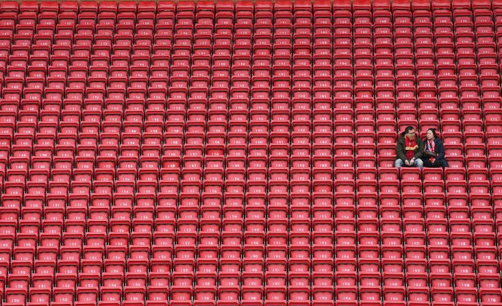 People sit in the stands of Anfield stadium in Liverpool, England before the start of the English Premier League soccer match between Liverpool and Bournemouth on March 7.