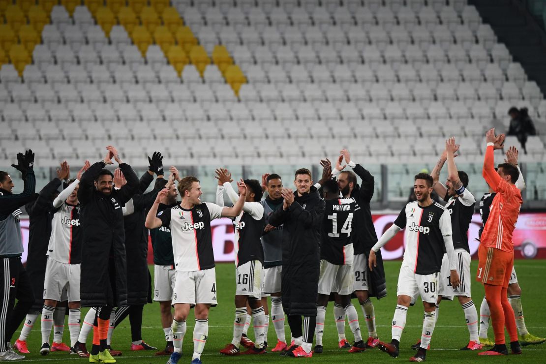 Juventus players applaud the empty stands after their win.