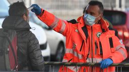 A health staff checks the body temperature of a man arriving at the Juventus stadium before the Italian Serie A football match Juventus vs Inter Milan which will be played behind closed doors, in Turin on March 8, 2020. - Italy's Sports Minister called on Matrch 8 for an immediate suspension of the Serie A season due to the coronavirus outbreak that has killed 233 people in the country. (Photo by Vincenzo PINTO / AFP) (Photo by VINCENZO PINTO/AFP via Getty Images)