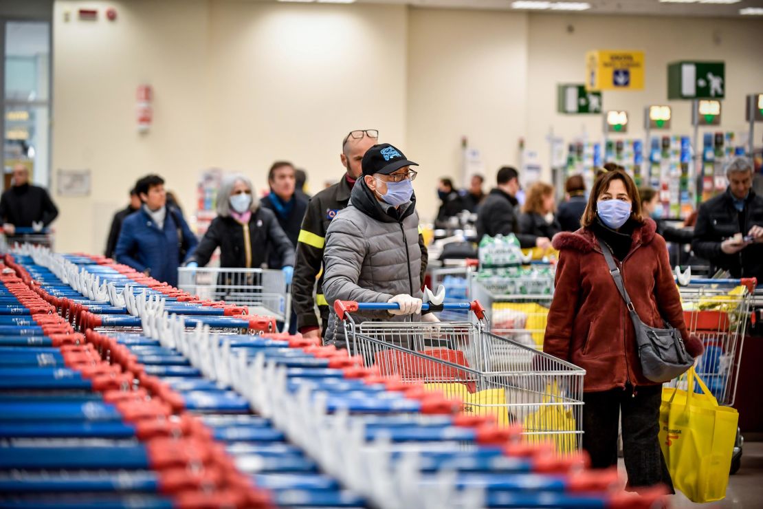 People wear masks while shopping at a supermarket in Milan, after Italy announced a sweeping quarantine zone covering its northern regions.