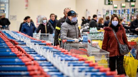 People wear masks while shopping at a supermarket in Milan, after Italy announced a sweeping quarantine zone covering its northern regions.