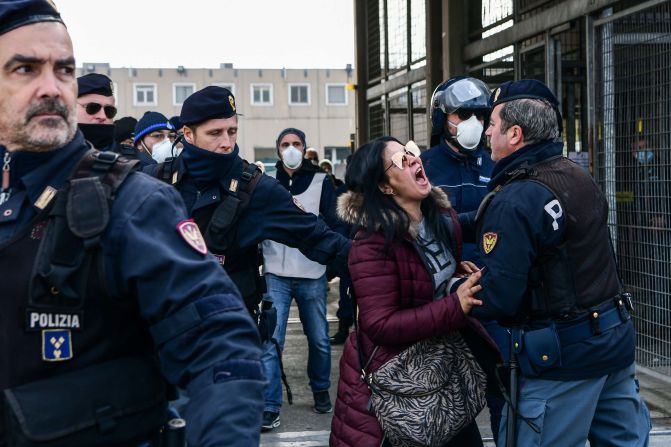 Police officers restrain the relative of an inmate outside the Sant'Anna jail in Modena, Italy, on March 9, 2020. <a href="https://www.cnn.com/asia/live-news/coronavirus-outbreak-03-09-20-intl-hnk/h_950c62671e245816c223fb84f1306fe6" target="_blank">Riots broke out</a> in several Italian jails after visits were suspended to curb the spread of the coronavirus.