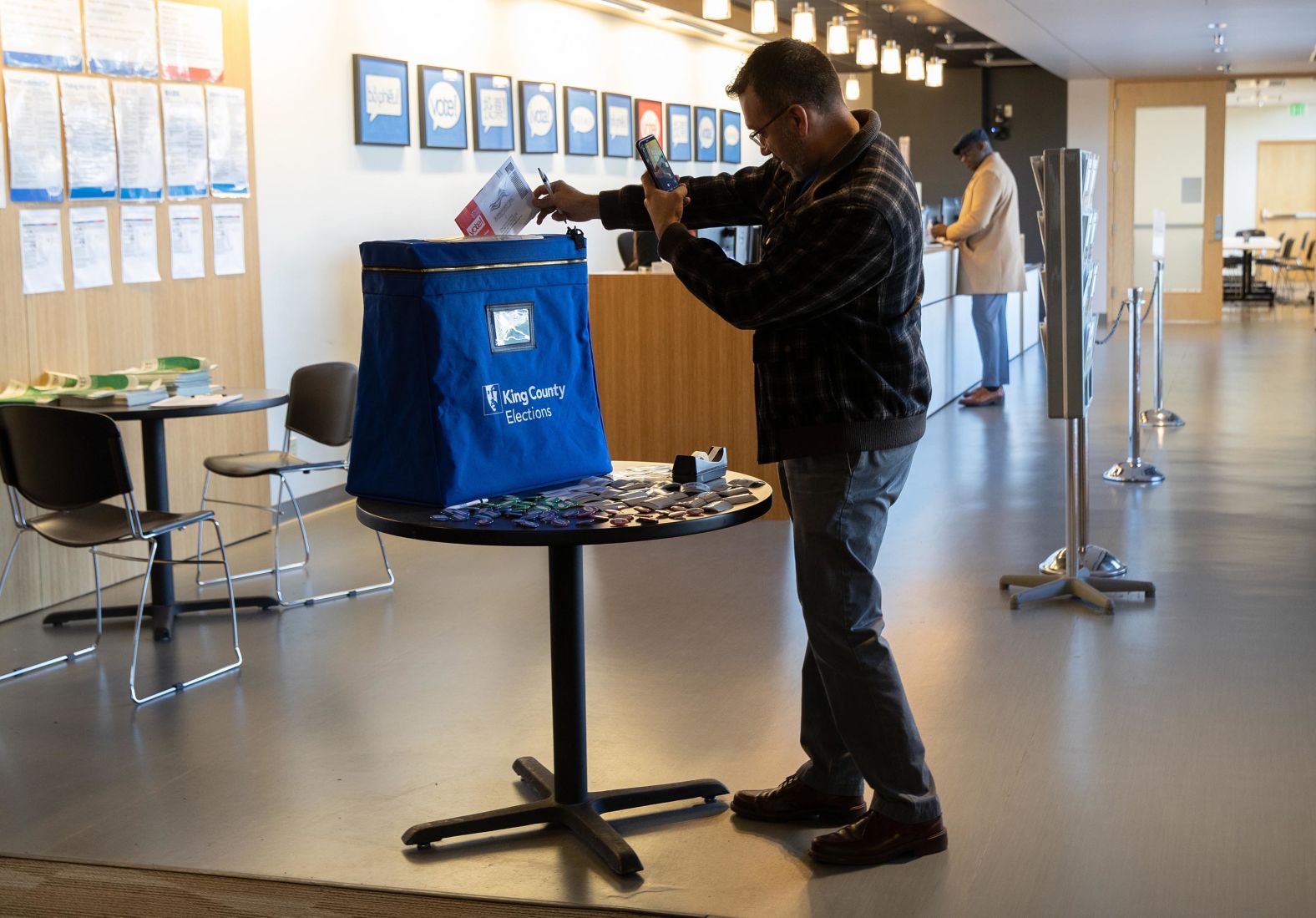 A voter takes a photo of himself dropping off his ballot in Renton, Washington, on Monday.