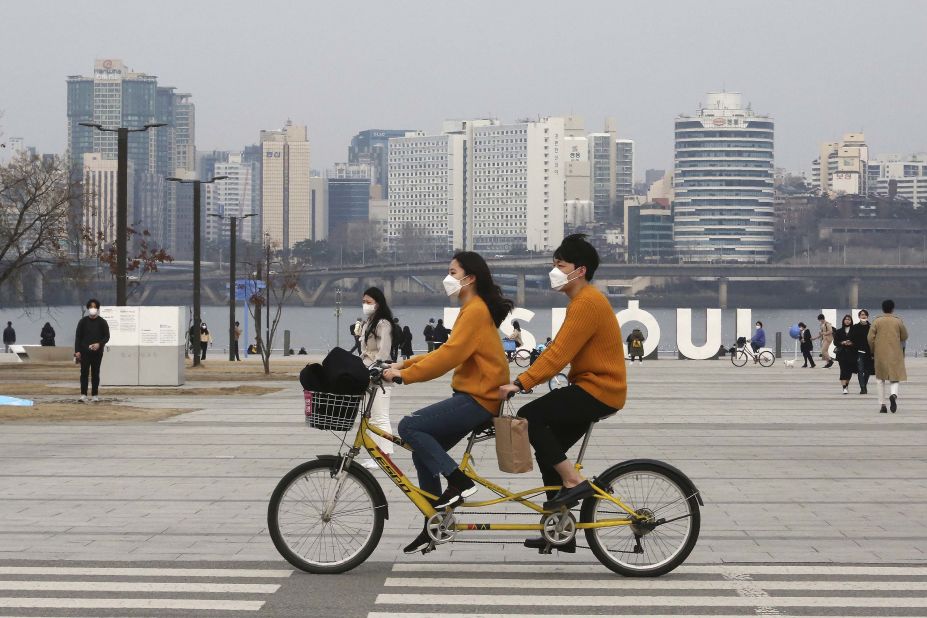 A couple rides a bicycle at a park in Seoul, South Korea, on March 7. 