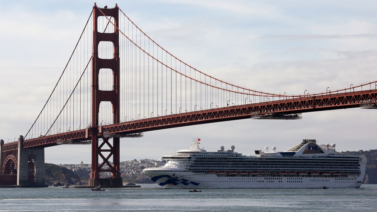 The Grand Princess cruise ship passes beneath the Golden Gate Bridge Monday. At least 21 people have tested positive for coronavirus aboard the ship.