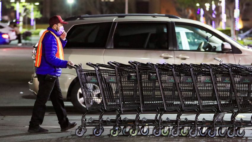 A staff member wearing a face mask pushes the shopping carts outside a supermarket in Los Angeles, California, the United States, March 4, 2020.  California Governor Gavin Newsom on Wednesday declared a state of emergency in response to the COVID-19 outbreak, hours after the first death caused by the disease was reported in the U.S. state. (Photo by Li Ying/Xinhua/Getty Images)