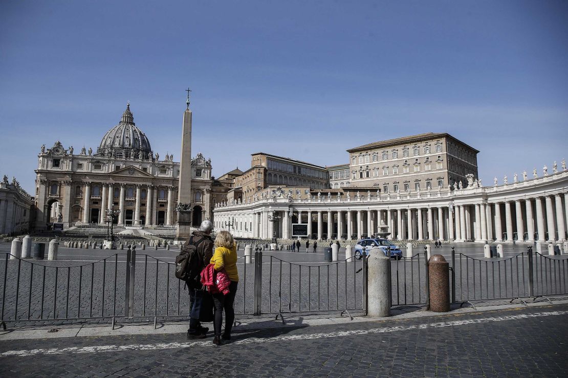 A couple looks at the closed St. Peter's Square at the Vatican on Monday, after a decree ordering restrictions across Italy to beat the spread of the coronavirus.