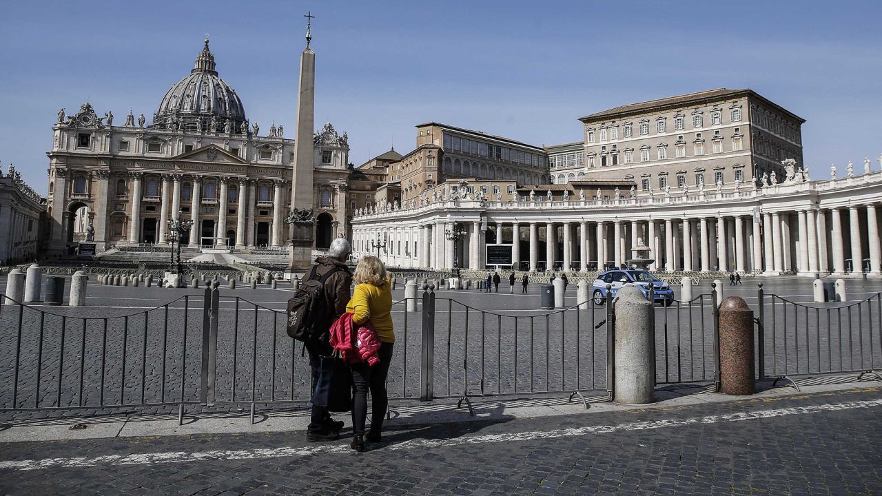 A couple looks at the closed St. Peter's Square at the Vatican on Monday, after a decree ordering restrictions across Italy to beat the spread of the coronavirus.