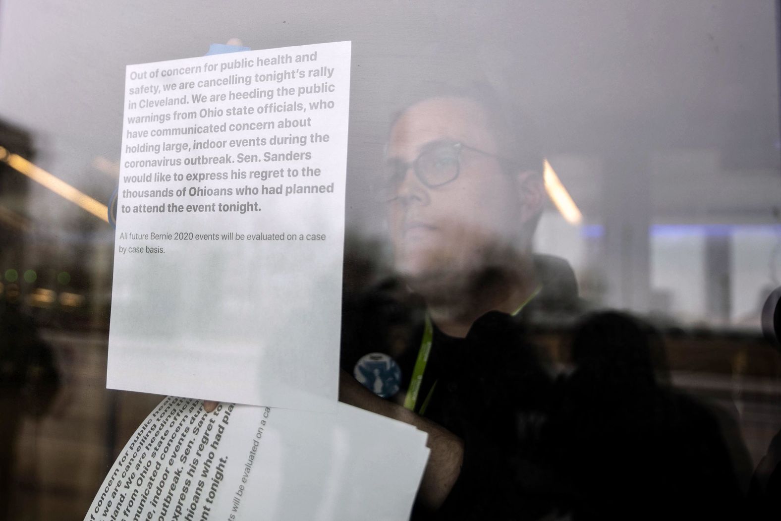 A Sanders staff member posts a cancellation note on the doors of the Huntington Center in Cleveland.