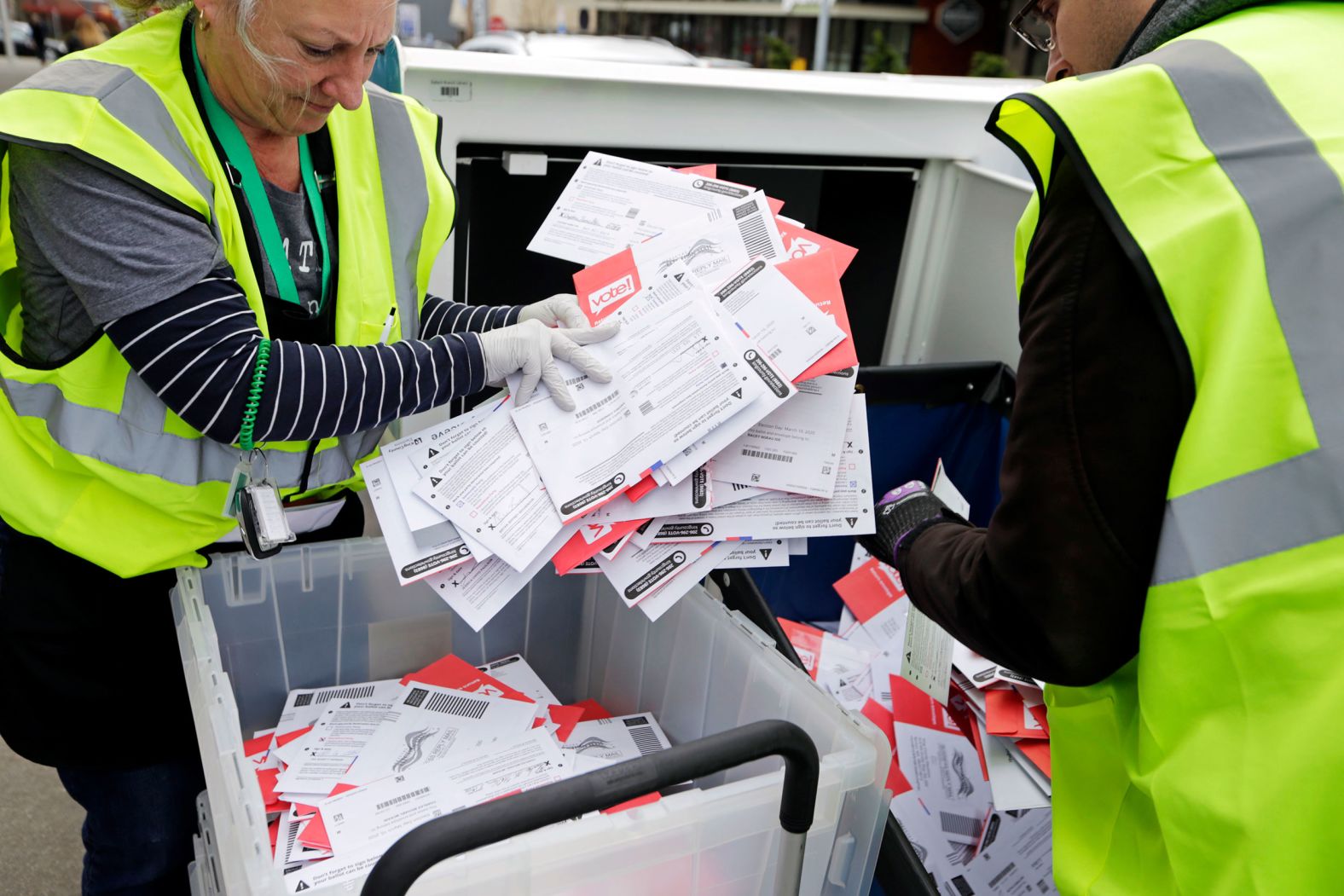 Election workers in Seattle collect ballots from a drop box on Tuesday. In Washington, voting is done by mail. People can also drop off their ballots at designated places.