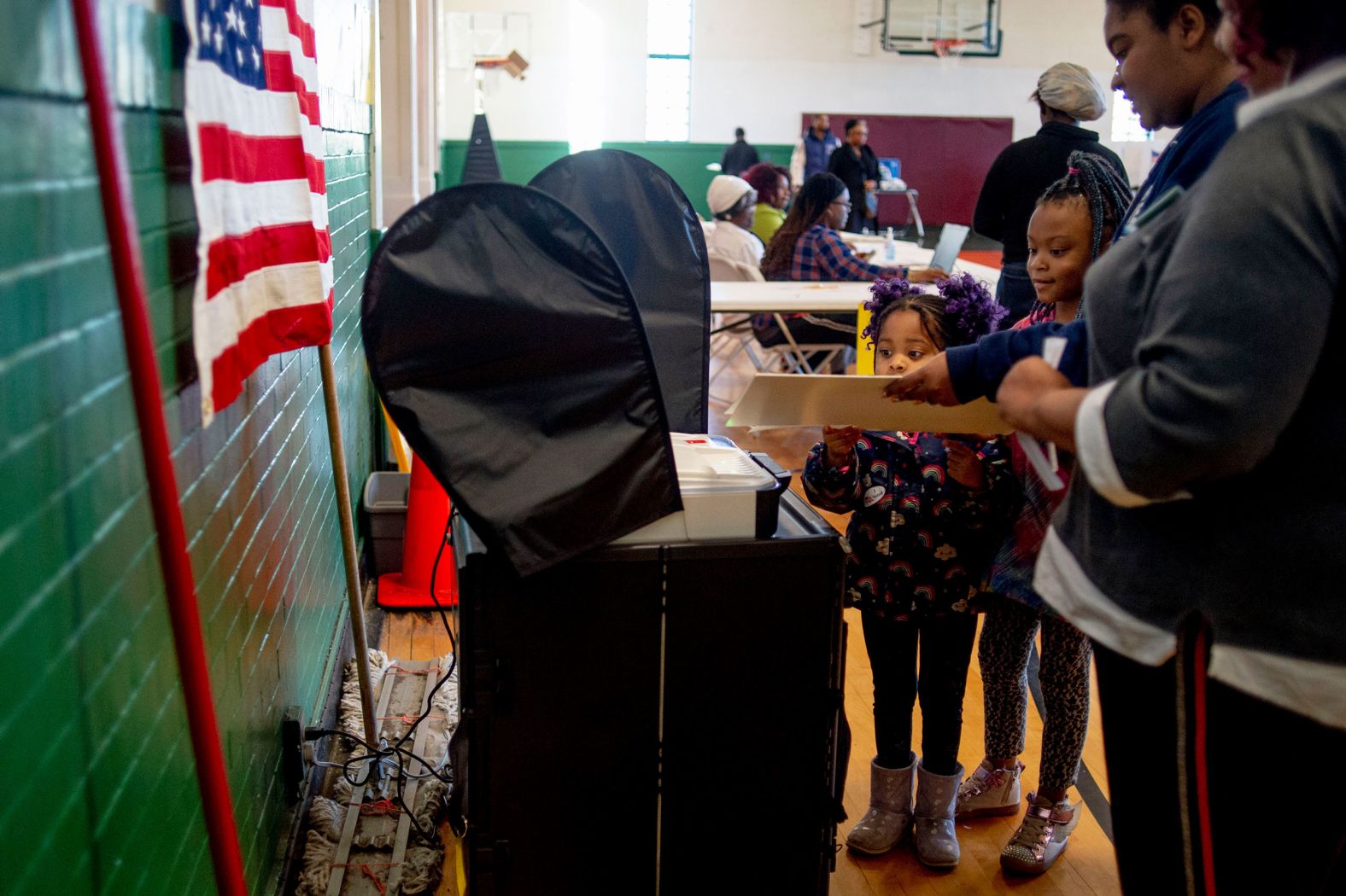 Young girls help their mother submit her ballot in Flint, Michigan, on Tuesday.